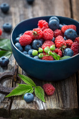 Sweet blueberries and raspberries on old wooden table