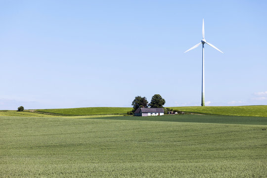 Farm windmill and green field