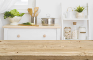 Fototapeta na wymiar Table top with blurred kitchen furniture as background