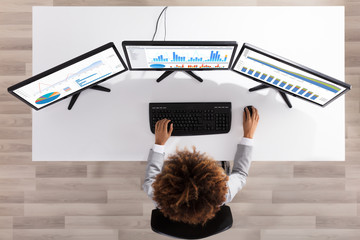 Businesswoman Analyzing Graph On Multiple Computers