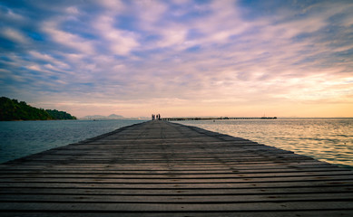 Naklejka na ściany i meble Wood bridge pier with beautiful sunrise sky and clouds in the morning use for natural background. Tourist walk on wooden pier to the sea