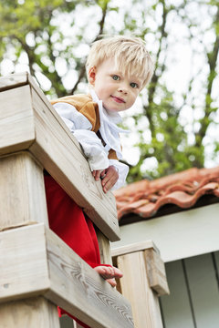 Portrait of little boy wearing pirate costume playing in wooden fort
