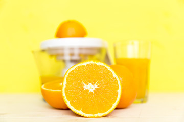 Juicer with citrus fruits. Preparation of orange juice, hands squeeze juice on a manual surrounded by fresh tropical fruit.