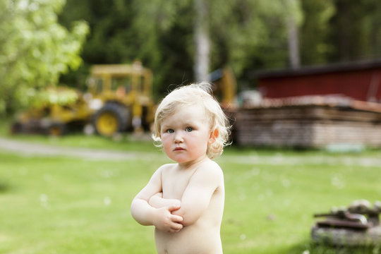 Portrait of shirtless baby boy standing outdoors