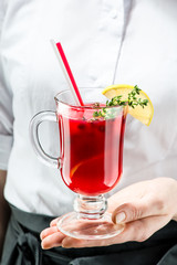 The unidentified waiter brings a hot cranberry gin cocktail for a customer