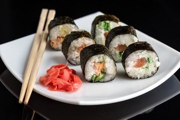 Japanese rolls on a white plate with ginger