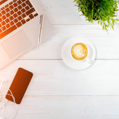 Woman workspace with laptop, smart phone and a cup of coffee