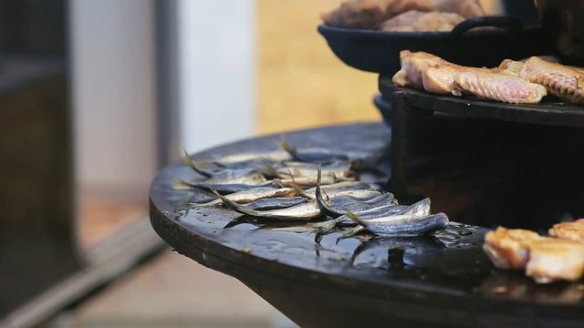Horse-mackerel and chicken wings roasted on the round barbecue