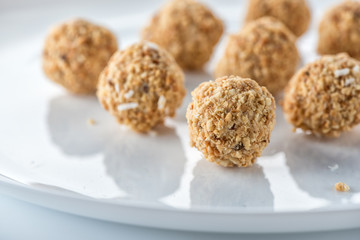 Sweets in peanut shavings on a white plate