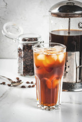 Trendy drinks. Cold brew iced coffee on white marble table. copy space