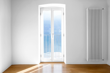 Empty room with large windows and antique beams