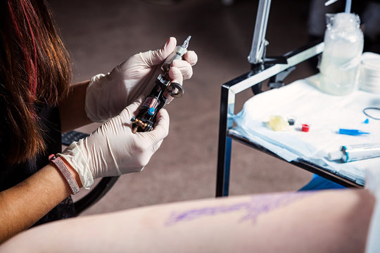 Close up tattoo artist at work. preparing the needle and the tattoo machine.