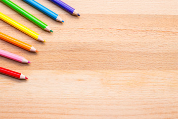 colorful pencils on wooden background