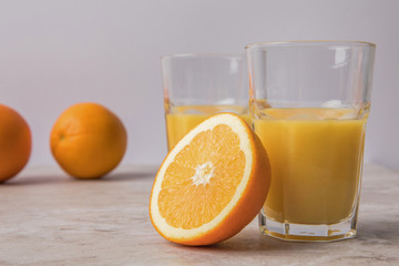 homemade orange juice and oranges on marble table