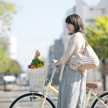 自転車で買い物をする女性