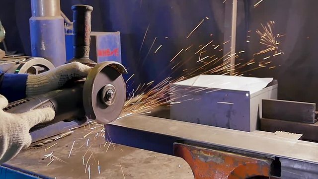 Worker cutting metal. Cutting metal angle grinder. Worker cutting metal with grinder. Sparks while grinding iron