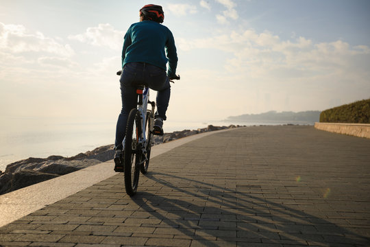 cyclist riding bike on the coast looking at the sunrise