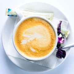 Delicious hot latte coffee with art in a white cup. Top view, flat lay