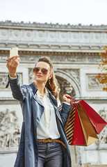 Fototapeta premium young woman shopper in Paris, France taking selfie with phone