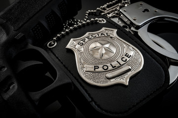 Protect and serve, crime fighting and blue lives matter concept with a police badge, a gun and a pair of handcuffs at night
