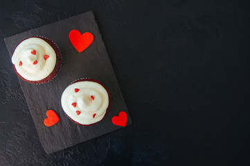 Red velvet cupcakes with cream cheese frosting on a white plate