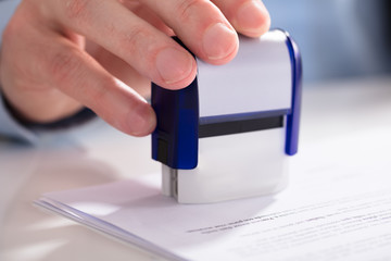 Businessperson Using Stamper On Document