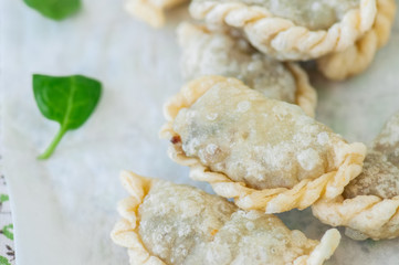 Fried savory pasties - hand pies with spinach on a white background. Top view and copy space.