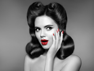 Pinup Woman with red lips and nails surprise holds cheek by hand. Beautiful girl with curly hair surprised and shocked looking to the side. Expressive facial expressions.
