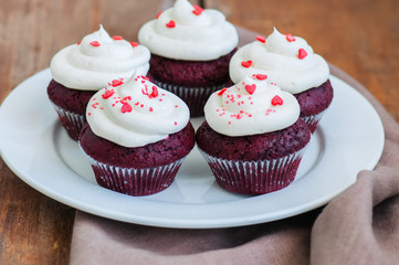 Red velvet cupcakes with cream cheese frosting on a white plate