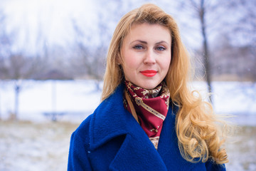 Happy and smiling woman on weekend. Lady in a blue coat walks on the street enjoying fresh air away...
