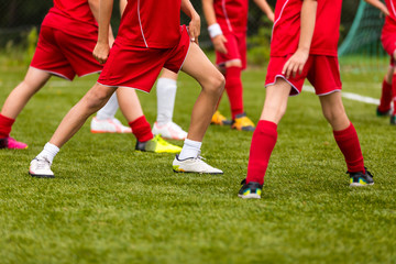 Obraz premium Soccer Training Session for Kids. Young Football Players Stretching Before the Match. Youth Football Team