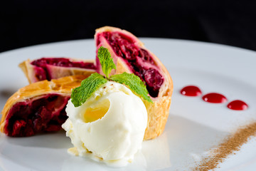 Sliced homemade delicious cherry strudel on a white plate