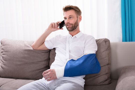 Man With Fractured Hand Talking On Mobile Phone