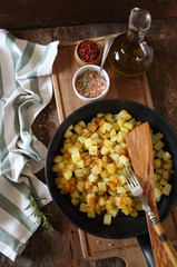 Fried potato cubes with olive oil and pink salt. Top view, rustic style