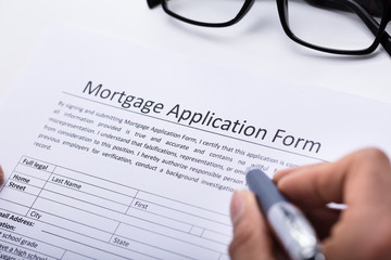 Human Hand Filling Mortgage Application Form