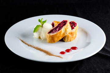 Sliced homemade delicious cherry strudel on a white plate