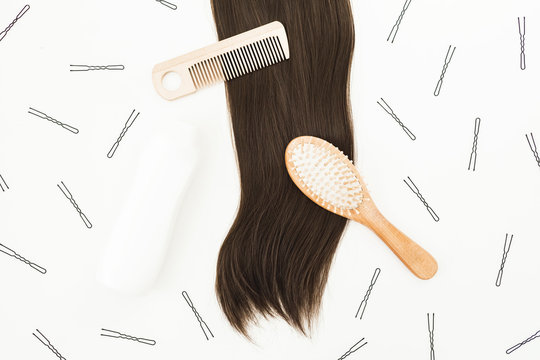 Tools for hairdresser with shampoo and hairs on white background. Flat lay, top view