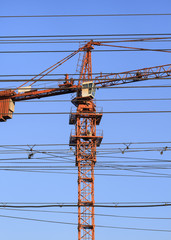 Orange construction crane against a blue sky