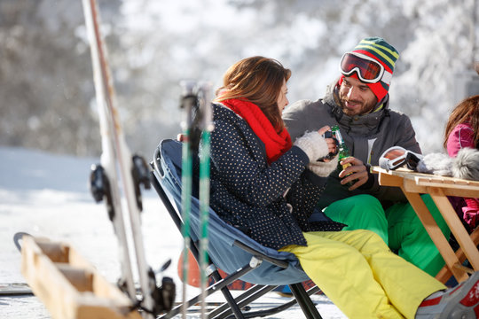 Male skier toasting with female skier