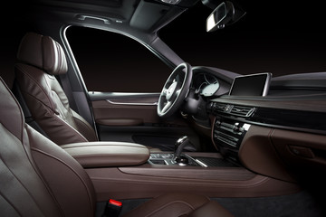 Modern luxury car Interior - steering wheel, shift lever and dashboard. Car interior luxury. Beige comfortable seats, steering wheel, dashboard, speedometer, display. Brown perforated leather.