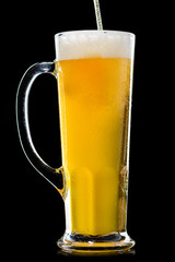 A glass of frosty fresh light unfiltered beer with straw on dark background