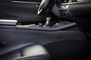 Dark luxury car Interior - steering wheel, shift lever and dashboard. Car interior luxury. Beige comfortable seats, steering wheel, dashboard, climate control, display.