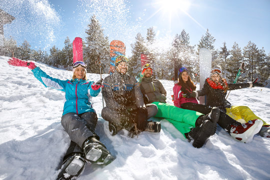 Group of skiers sitting on snow and enjoying