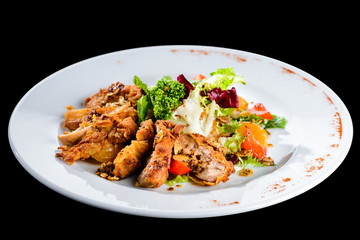 Delicious juicy roasted meat with spices and parsley in a white plate on dark background