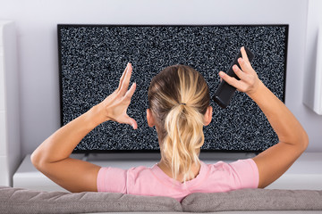 Woman Frustrated With A TV Screen Glitch