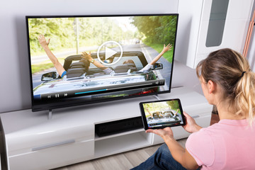 Woman Using Digital Tablet To Watching Television