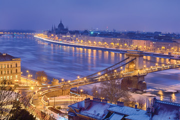Winter twilight view of Budapest with Pest riverfront, Parliament domes outline and Chain bridge