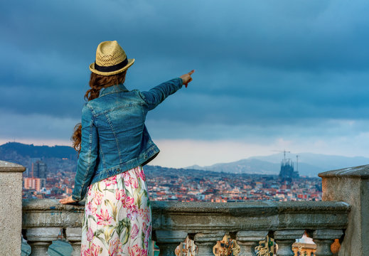 woman in front of cityscape of Barcelona pointing at something