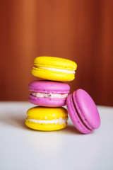 Vibrant colorful macarons on white wooden table. Text space