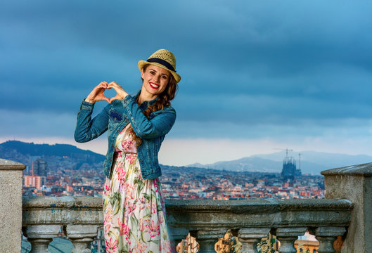 smiling elegant traveller woman showing heart shaped hands